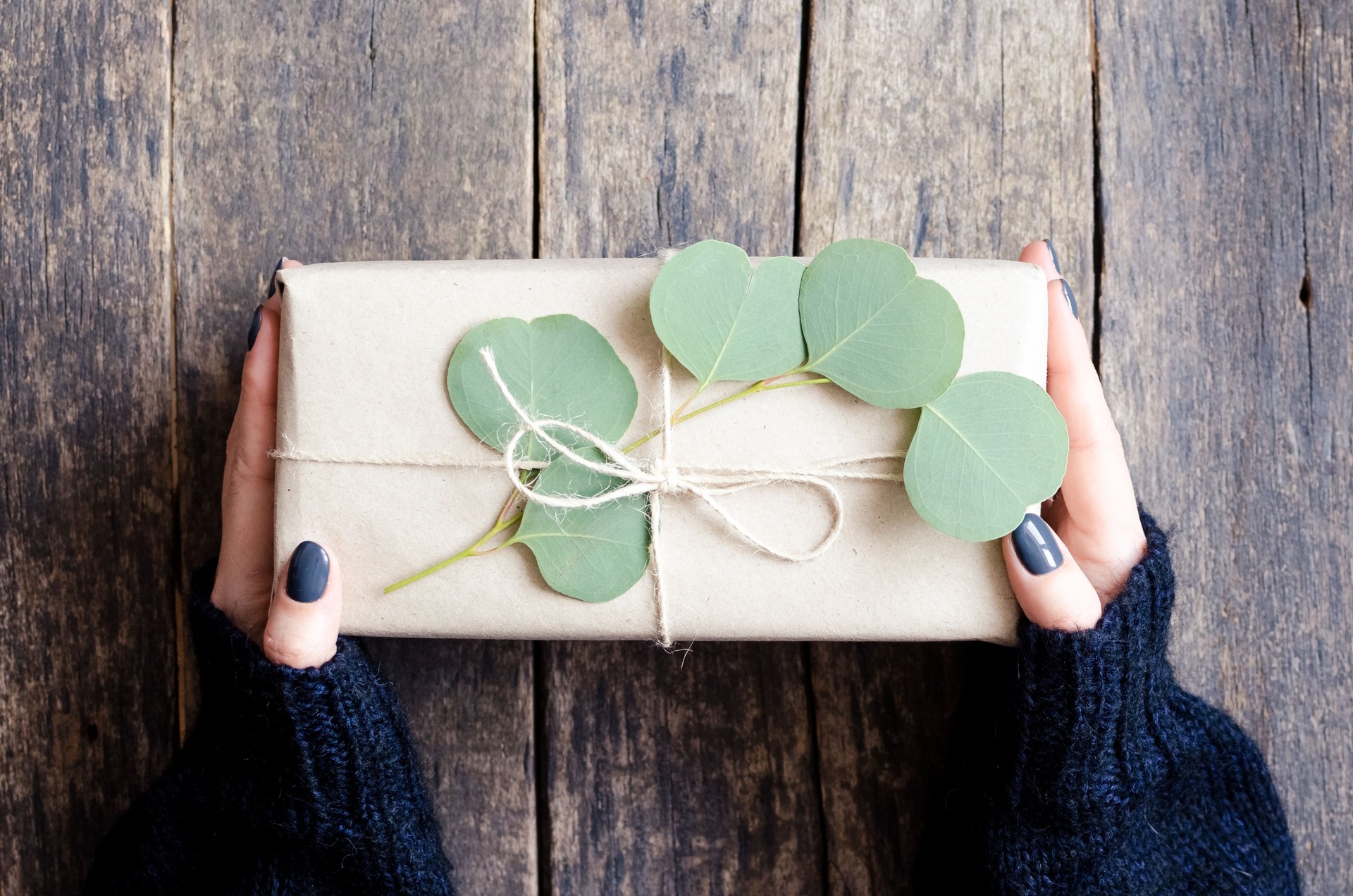 Gift box wrapped in brown paper decorated with eucalyptus branch