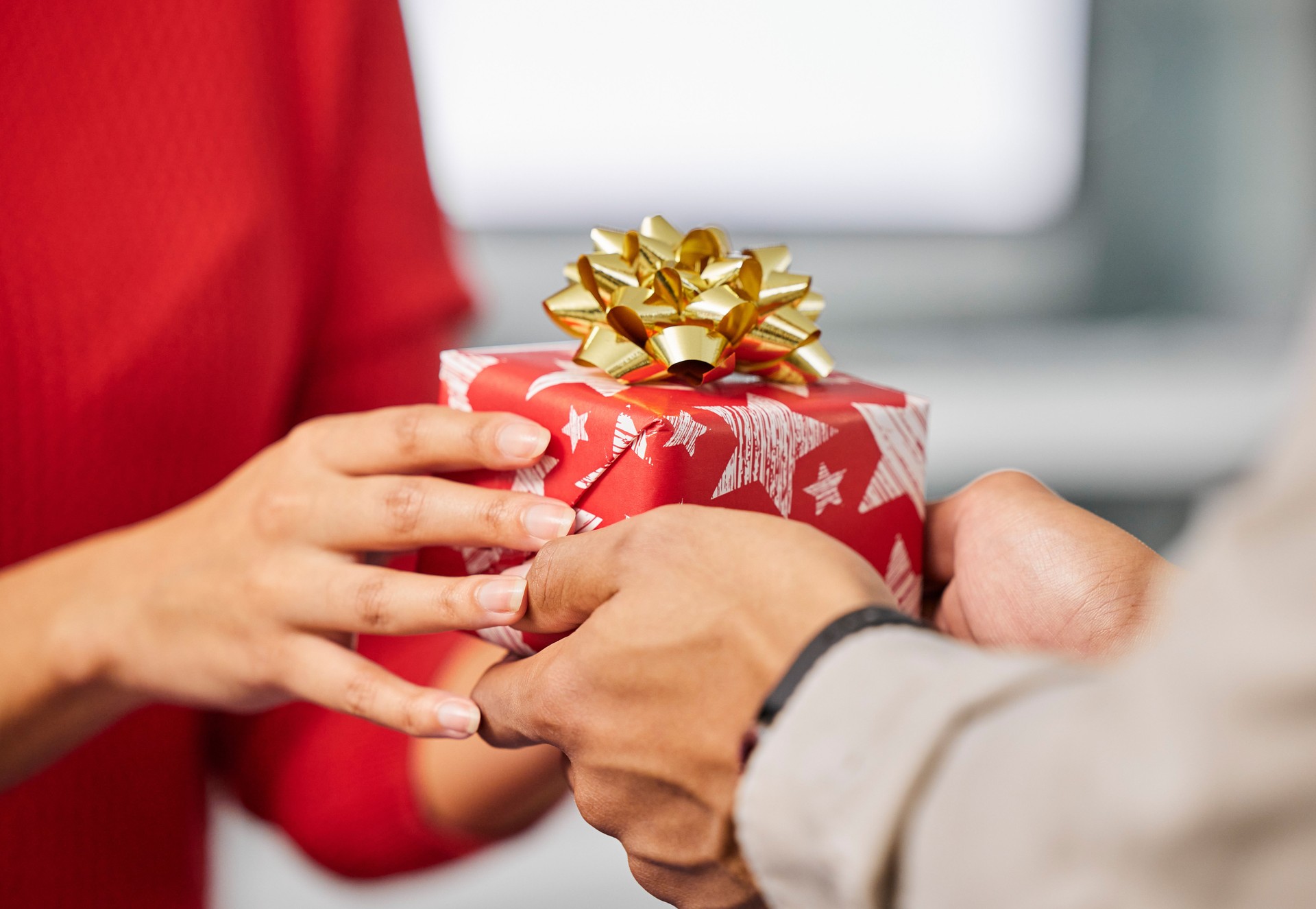 Shot of an unrecognisable businessman and businesswoman exchanging Christmas gifts in a modern office